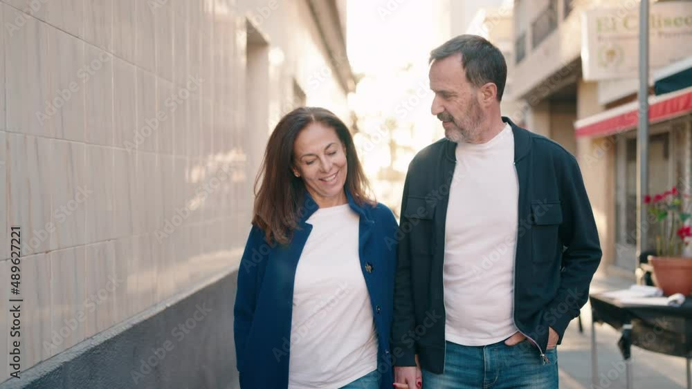 Man and woman couple walking with hands together at street Man and woman couple walking with hands together at street