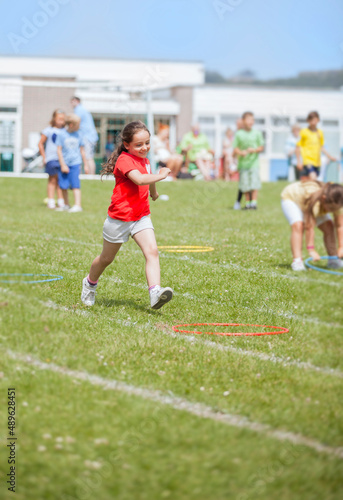 Fototapeta Naklejka Na Ścianę i Meble -  Young girl running at the school sport's day