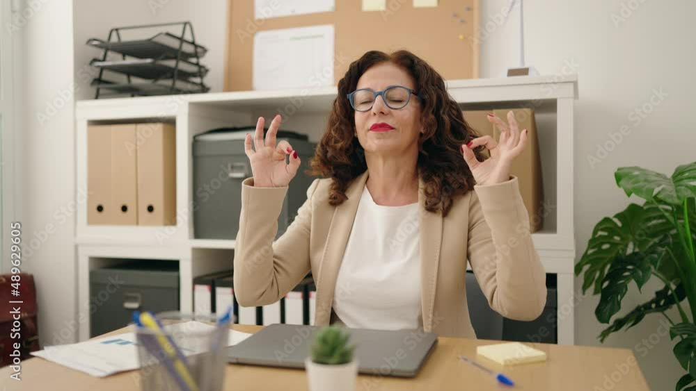 Middle age woman business worker doing yoga exercise at office Middle age woman business worker doing yoga exercise at office