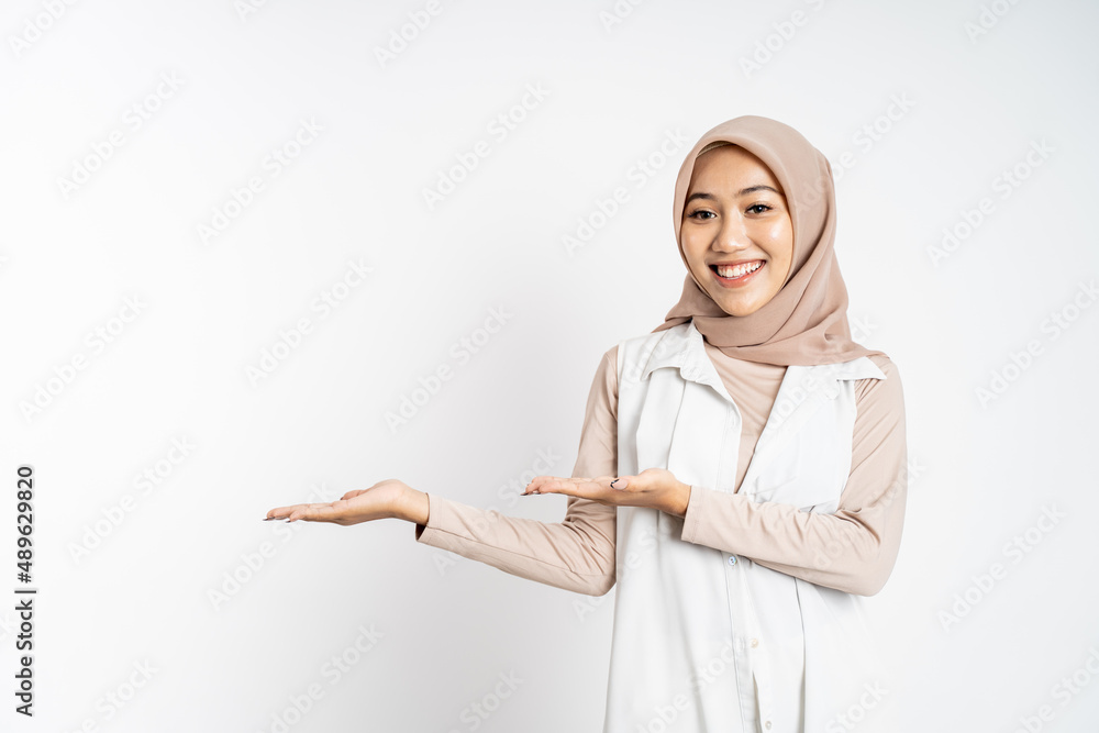 Young hijab woman with hand gesture presenting something Young hijab woman with hand gesture presenting something