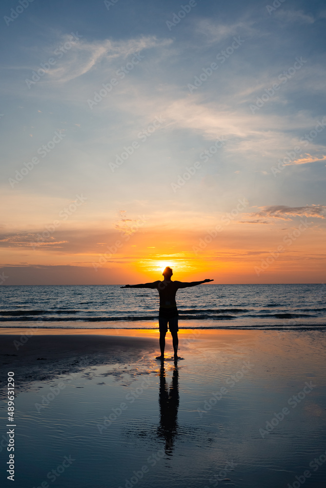 Silhouette of Man Stanidng on Beach at Sunset