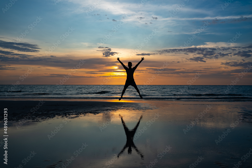 Silhouette of man Jumping on Beach at Sunset Silhouette of man Jumping on Beach at Sunset