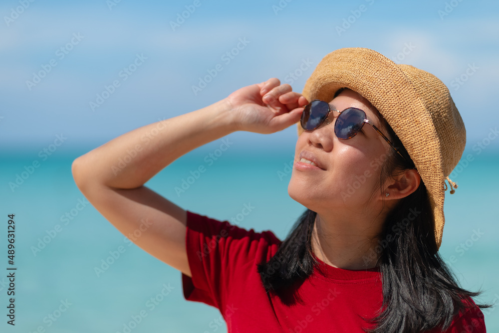 Portrait of Asian Mature Adult Woman Wearing Sunglasses with Ocean Background