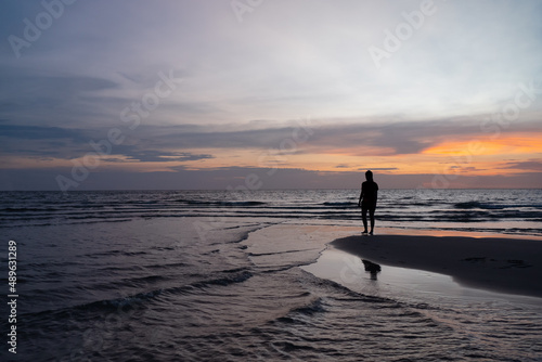 Silhouette of Woman Stanidng on Beach at Sunset