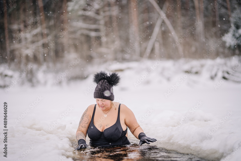 Beautiful chubby girl in winter swim, winter hardening therapy, ice cold swim in the river Beautiful chubby girl in winter swim, winter hardening therapy, ice cold swim in the river