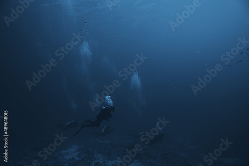 divers underwater at depth in the blue sea background