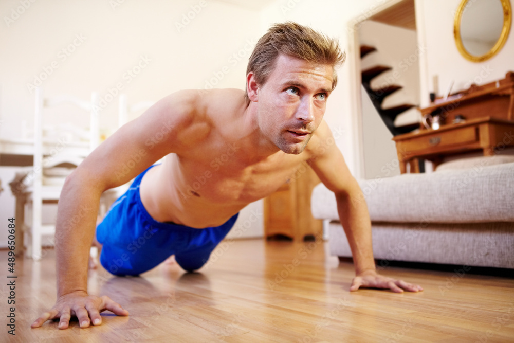 Determined to reach 100. Handsome young guy doing push-ups at home. Determined to reach 100. Handsome young guy doing push-ups at home.