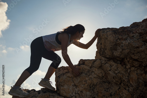 hiking woman climb to montain peak at sunset