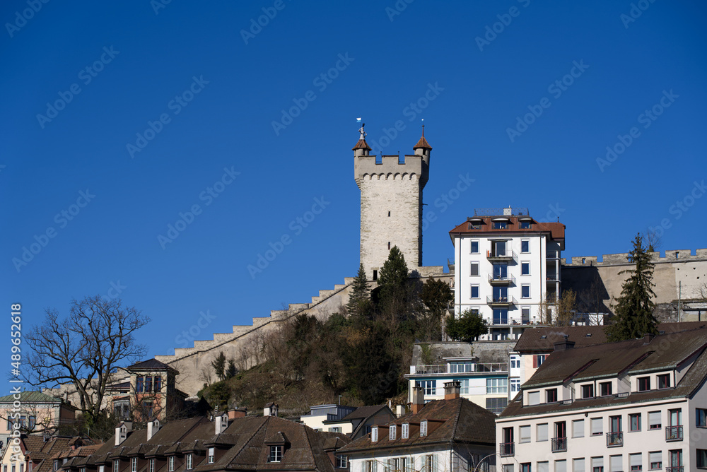 Cityscape with medieval city wall and guard towers on a sunny winter day. Photo taken February 9th, 2022, Lucerne, Switzerland.