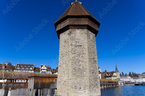 Medieval old town of Luzern with famous covered wooden Chapel Bridge (German: Kapellbrücke) and stone water tower on a sunny winter day. Photo taken February 9th, 2022, Lucerne, Switzerland.