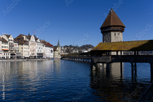 Medieval old town of Luzern with famous covered wooden Chapel Bridge (German: Kapellbrücke) and stone water tower on a sunny winter day. Photo taken February 9th, 2022, Lucerne, Switzerland. © Michael Derrer Fuchs