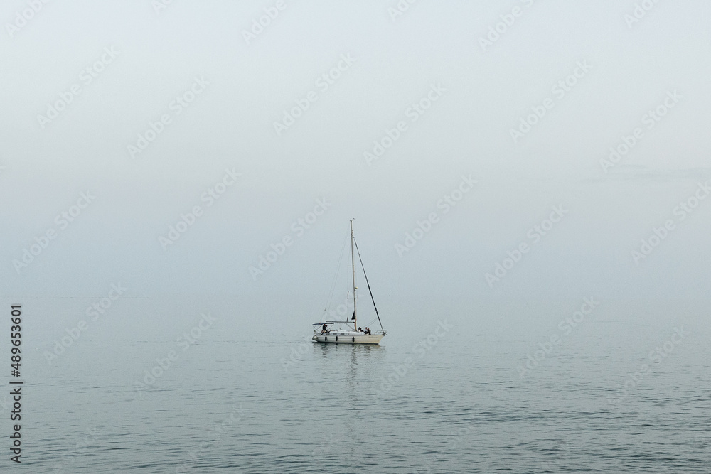 Lonely sailboat out on the ocean off the Mediterranean Sea in Sitges, Spain. Lonely sailboat out on the ocean off the Mediterranean Sea in Sitges, Spain.