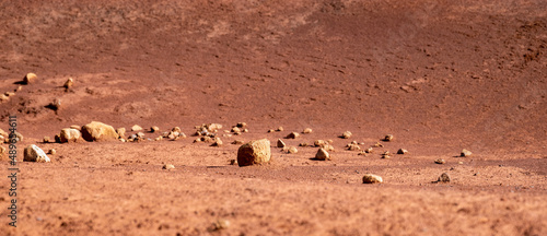 A hill of eroded red clay dirt, scattered small rocks and pebbles in the Garden of the Gods on Lanai, Hawaii.