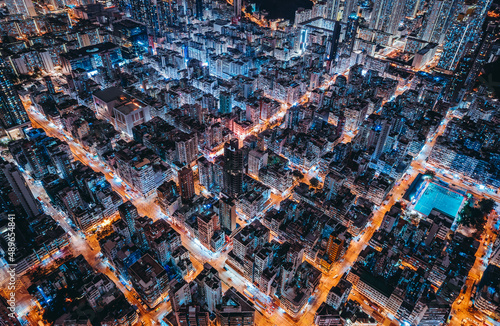 Aerial view of intersection in Hong Kong Downtown. Financial district and business centers in smart city, technology concept. Top view of buildings at night.