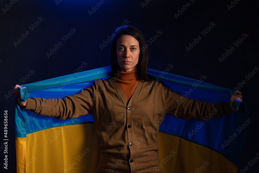 Sad woman holding Ukraine flag. Concept of standing with Ukrainian nation in war with Russia. Sad woman holding Ukraine flag. Concept of standing with Ukrainian nation in war with Russia.