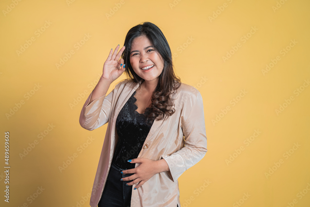 Young woman smiling with okay hand gesture on isolated background Young woman smiling with okay hand gesture on isolated background