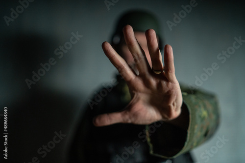 Frustrated military soldier showing hand to stop the war.
