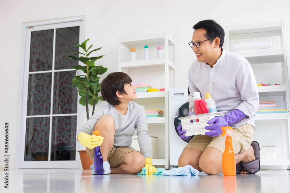 Asian father and son help each other to clean the floor for daily routine chores and housekeeping