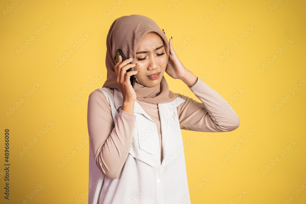 worried muslim woman in hijab making a call using a cell phone worried muslim woman in hijab making a call using a cell phone