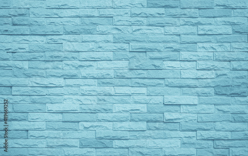Brick wall painted with pale blue paint calm tone texture background. Pattern clean concrete grid uneven bricks design stack backdrop.