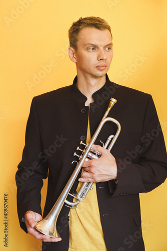 trumpeter in a black suit on a yellow background