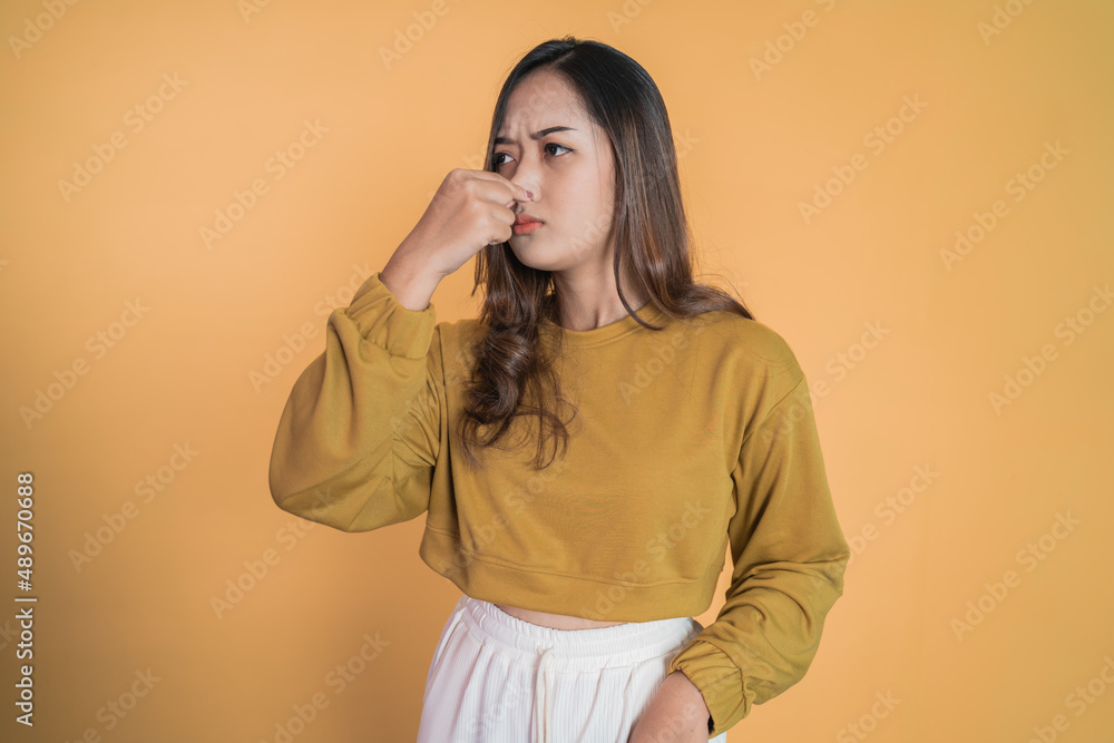 Young woman covering nose with finger when bad smell Young woman covering nose with finger when bad smell