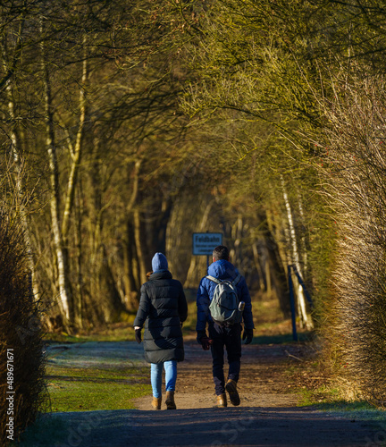 Young couple taking a spring walk in the forest in the Netherlands, with fresh green leafs and lots of warm sunshine © Daniel Wussow