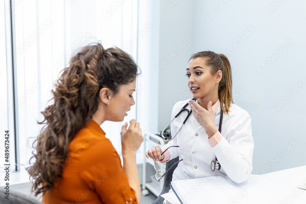 Coughing woman visiting doctor at clinic, patient coughing at medical appointment with her doctor. Sick woman visiting doctor at the hospital. Coughing woman visiting doctor at clinic, patient coughing at medical appointment with her doctor. Sick woman visiting doctor at the hospital.
