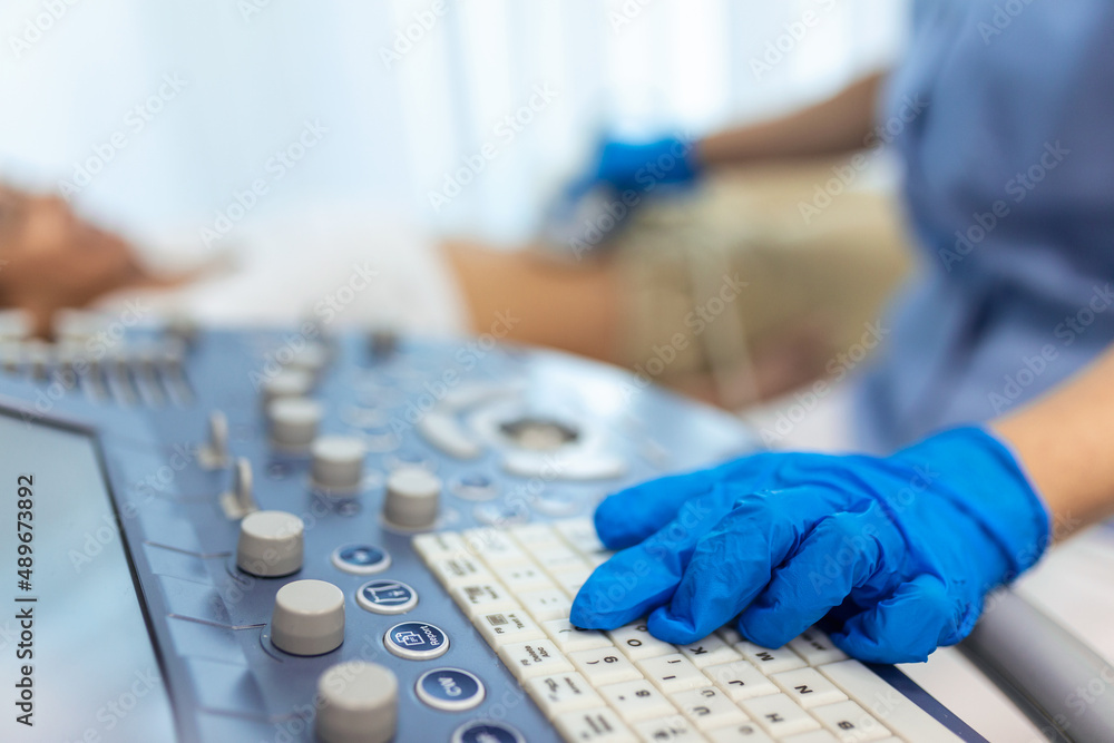 Skillful sonographer using ultrasound machine at work. woman visiting