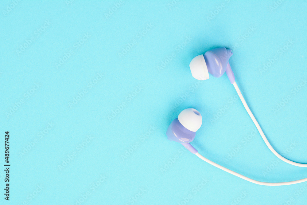 Blue ear phone on a blue background Blue ear phone on a blue background
