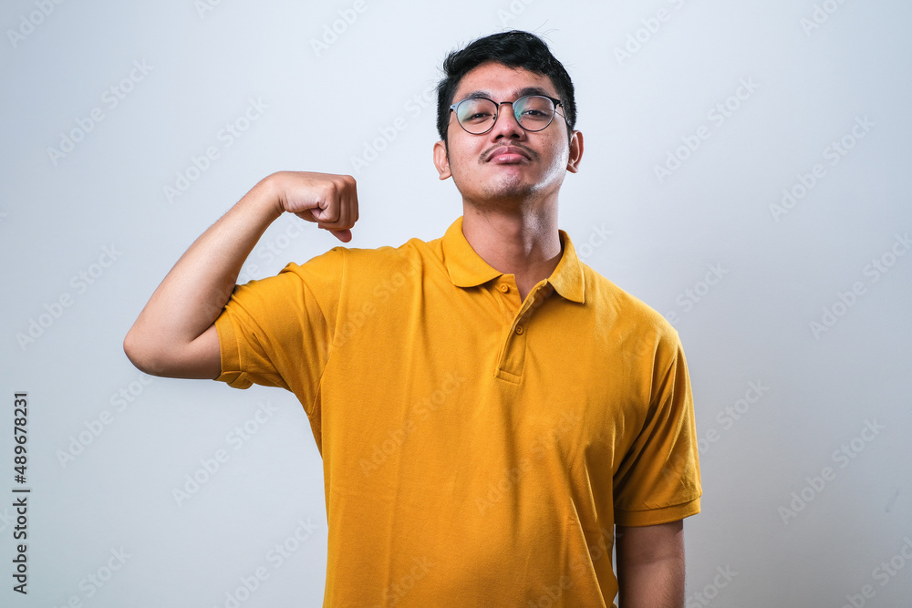 Young handsome asian man showing arms muscles smiling proud. fitness concept. Young handsome asian man showing arms muscles smiling proud. fitness concept.