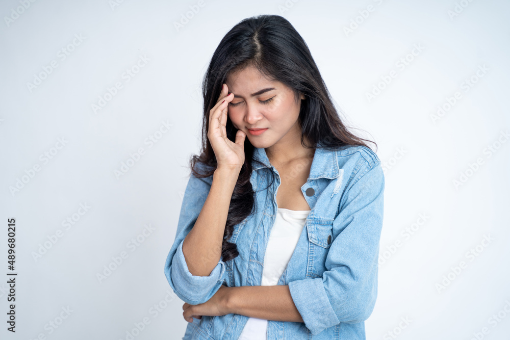Young woman holding head while confused by situation Young woman holding head while confused by situation