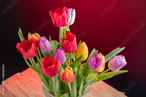 Fototapeta Naklejka Na Ścianę i Meble -  a big bouquet of tulips of various colours in crystal vase