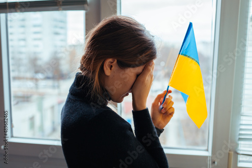 Valokuvatapetti Crying woman holding Ukrainian flag during war with Russia