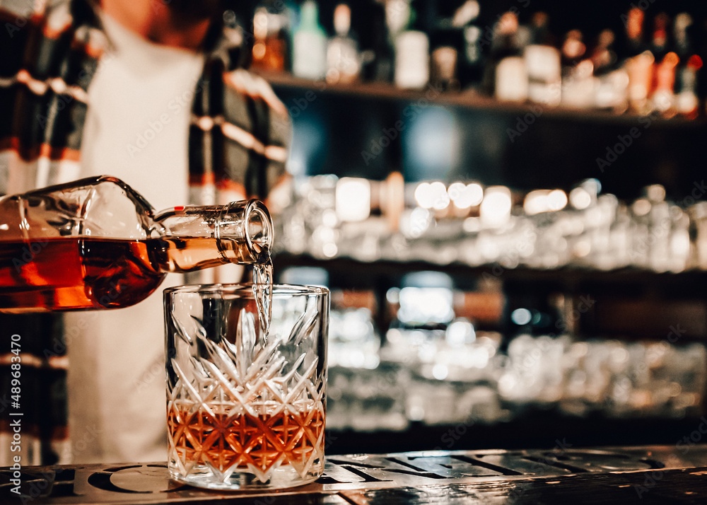 Bartender pouring whiskey on glass in bar - obrazy, fototapety, plakaty 