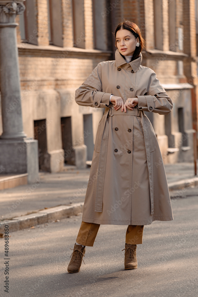 Fashionable girl walking down the street in a European city in a stylish coat Fashionable girl walking down the street in a European city in a stylish coat