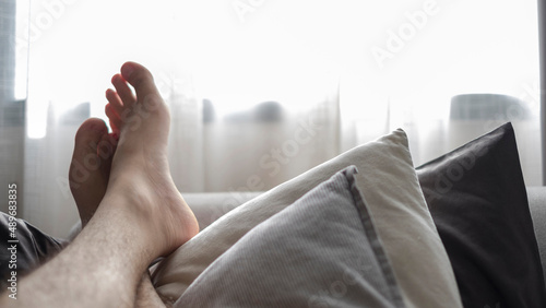 Feet of man relaxing on the sofa photo