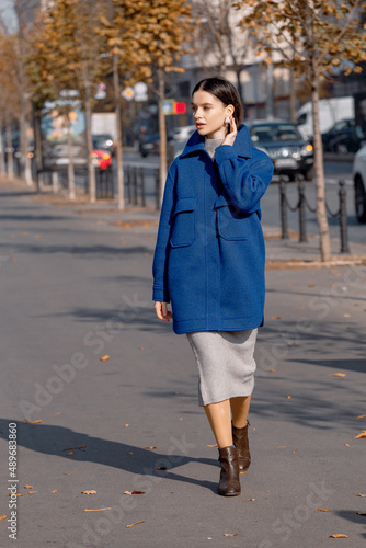 Fashionable girl walking down the street in a European city in a stylish coat © alexbutko_com