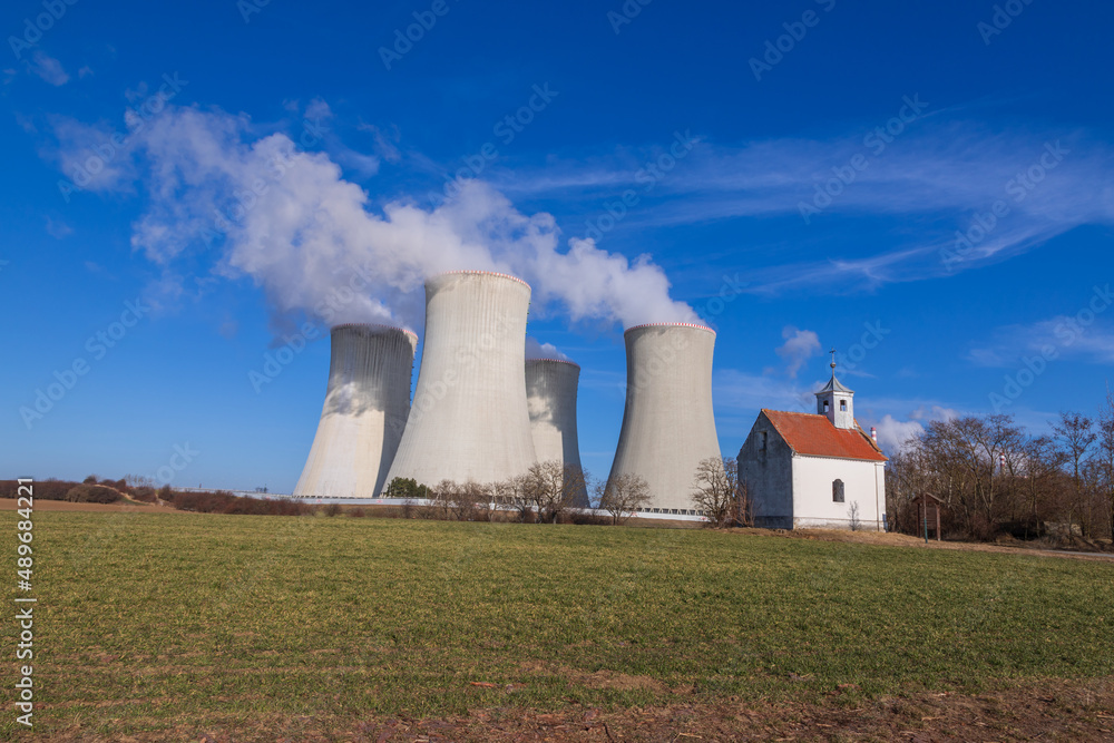 Dukovany Nuclear Power Plant in the Czech Republic, Europe. Smoke cooling towers. There are clouds in the sky. In the background the nature of the Highlands. Dukovany Nuclear Power Plant in the Czech Republic, Europe. Smoke cooling towers. There are clouds in the sky. In the background the nature of the Highlands.