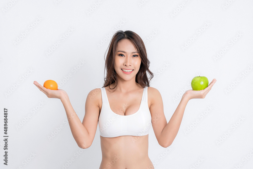 Beautiful asian young woman healthy food wearing white underwear holding green apple with healthy food isolated on a white background. Beautiful asian young woman healthy food wearing white underwear holding green apple with healthy food isolated on a white background.