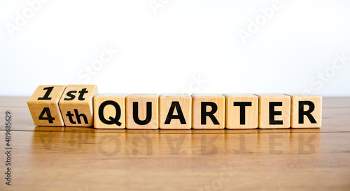 From 4th forth to 1st first quarter symbol. Turned wooden cubes and changed words 4th quarter to 1st quarter. Beautiful wooden table white background. Business happy 1st quarter concept, copy space. photo