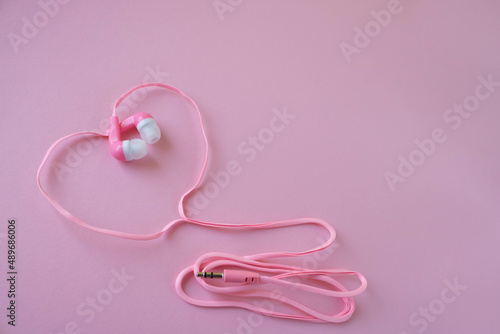 Pink headphones for the phone on a pink background