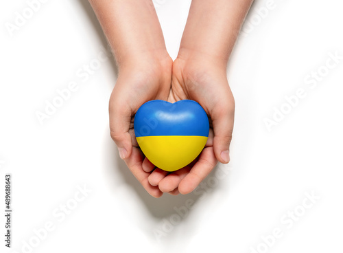 High angle view of child hands holding ukraine flag painted heart isolated on white background