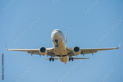 Looking up at a large jet aeroplane against a blue sky photo
