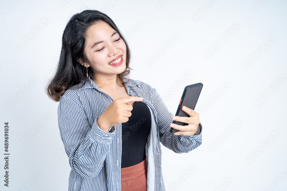 Young asian woman smiling while using a mobile phone Young asian woman smiling while using a mobile phone