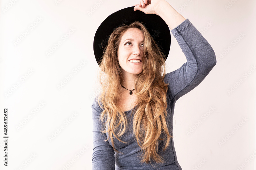A woman is smiling and feeling happy with her cap. She is looking at the camera, down or up. She is taking her long hair. A woman is smiling and feeling happy with her cap. She is looking at the camera, down or up. She is taking her long hair.