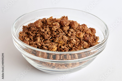 Granola in a transparent bowl on a white background. Healthy food.