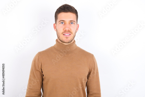 young caucasian man wearing grey turtleneck over white background with a happy and cool smile on face. Lucky person. © Roquillo