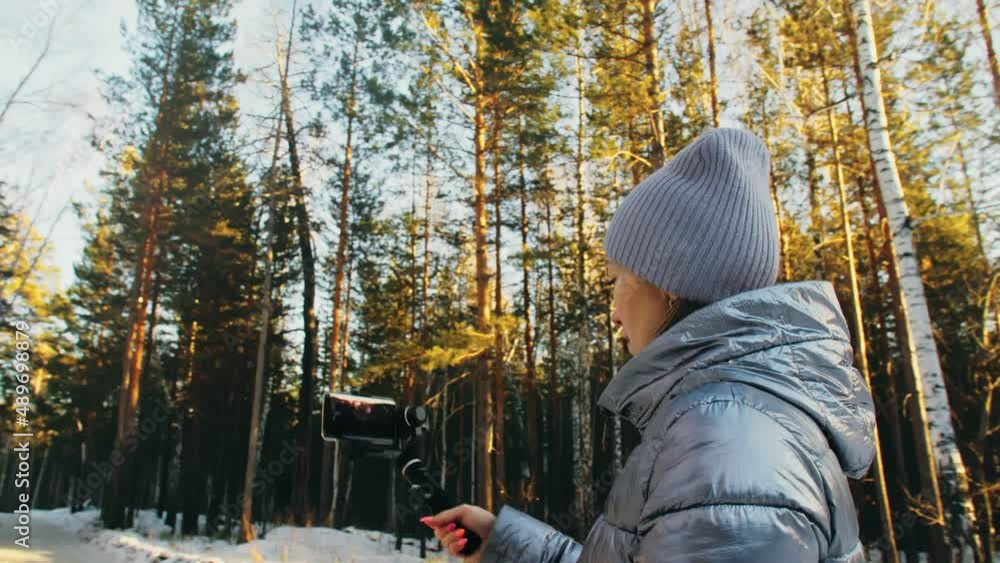 Woman Holding On Handheld Film 3-axis Gimbal Stabilization Device in Winter for Smartphone. Girl Blogger Make Selfie, Broadcast Video Blogging, Vlogging. Videographer Operator Take Photo Video. Woman Holding On Handheld Film 3-axis Gimbal Stabilization Device in Winter for Smartphone. Girl Blogger Make Selfie, Broadcast Video Blogging, Vlogging. Videographer Operator Take Photo Video.