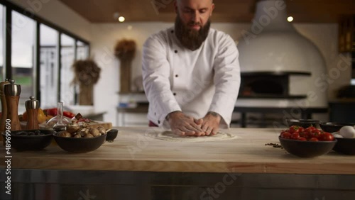 Culinary chef cooking pizza dough in restaurant kitchen. Pastry recipe concept. photo